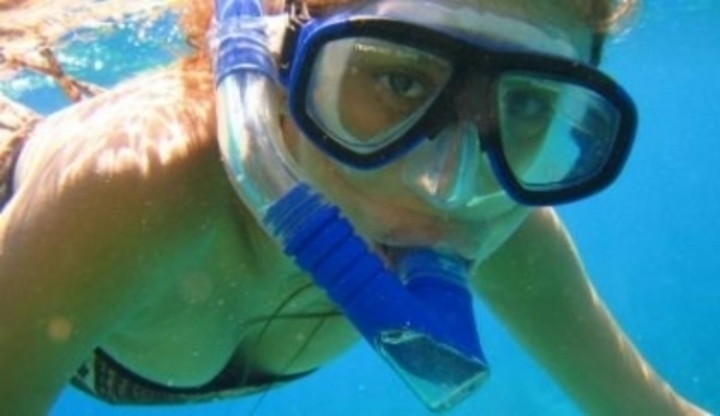 Žena pod vodou v potápěčských brýlích 