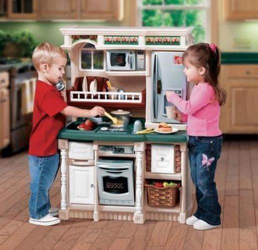 Děti hrající si s dětskou kuchyňkou 