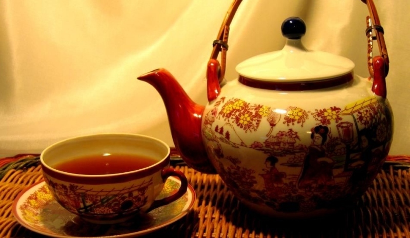 Čajová konvice s hrníčkem položeným na talířku 