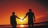 Dvojice držící se za ruce při západu slunce 