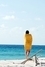 Dívka v žlutém ručníku na pláži