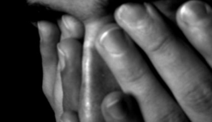 Ruce zakrývající mužský obličej