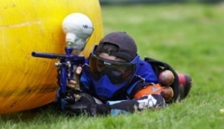Chlapec s paintballovou pistolí a ochranným oblečením 