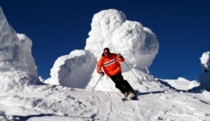 Muž na lyžích sjíždicí kopec
