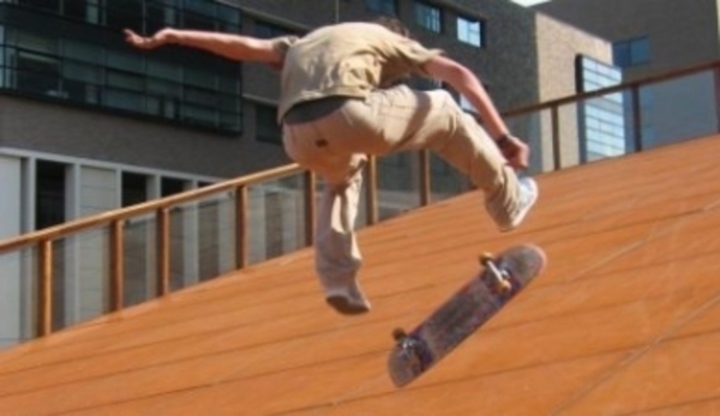 Muž při výskoku na skateboardu 