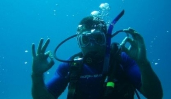 Muž pod vodou s potápěčským vybavením
