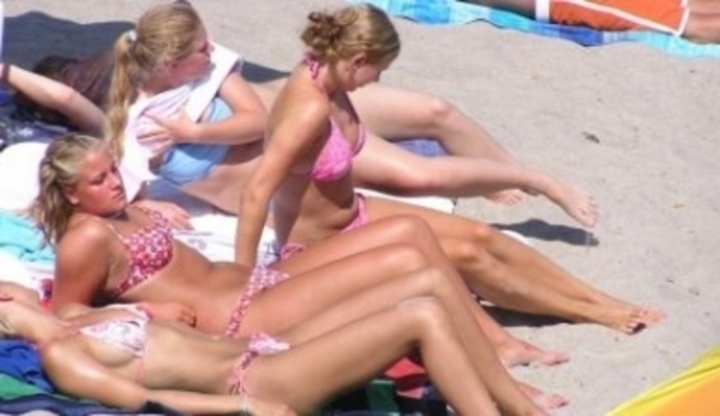 Ženy v plavkách opalující se na pláži