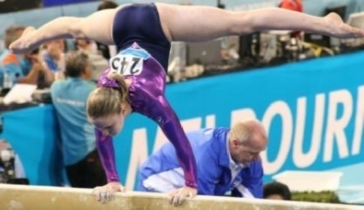 Žena na kladině předvádí gymnastický cvik