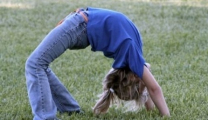 Dívka protahující se na trávě