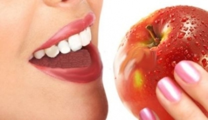 Žena s pootevřenými ústy držící jablko