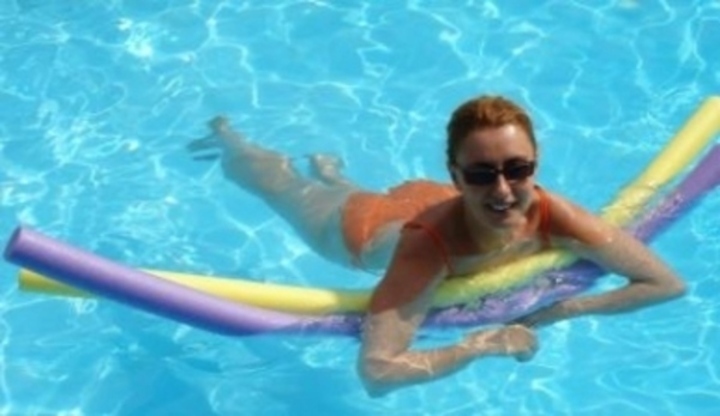 Žena v bazénu s pěnovou tyčí 