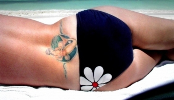 Žena v plavkách s tetováním na zádech