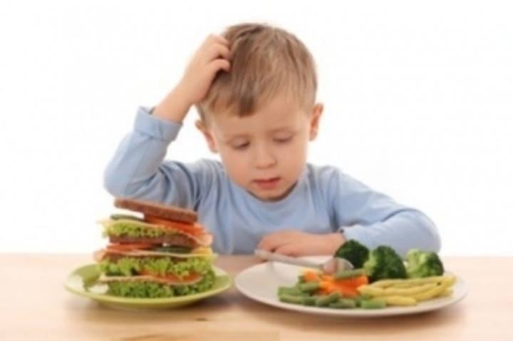 Dítě sedící u talířů plných zdravého jídla 