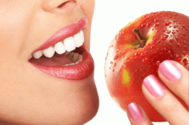 Žena s pootevřenými ústy držící jablko