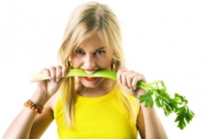 Žena držící zeleninu v ústech