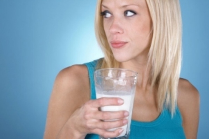 Žena držící sklenici mléka