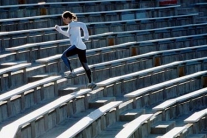 Žena běžící po schodech na stadionu