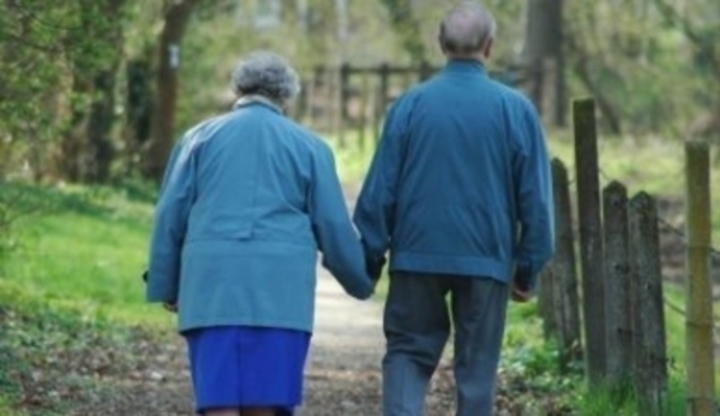 Starý pár na procházce držící se za ruce