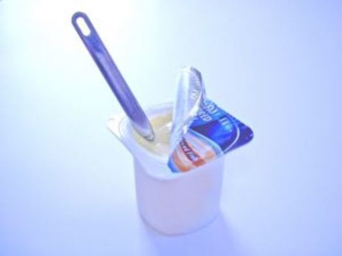 Kelímek jogurtu s ponořenou lžičkou