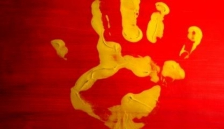 Otisk žluté barvy rukou na červeném podkladu