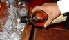 Nalívání alkoholu do sklenic s ledem 