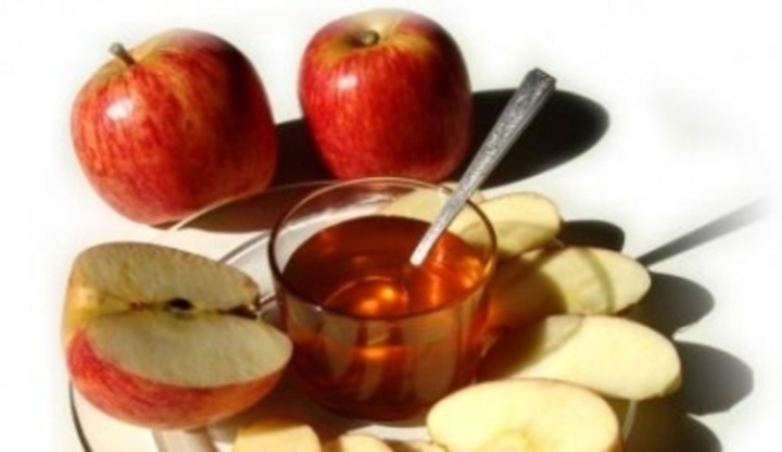 Nakrájená jablka se sklenicí medu