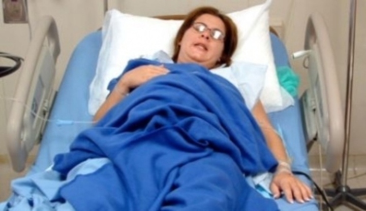 Žena ležící na nemocničním lůžku 