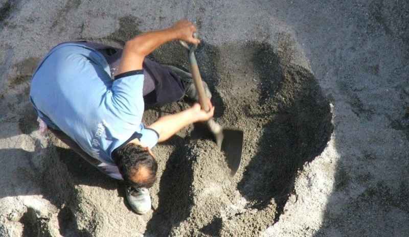 Muž kopající díru lopatou 