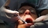 Muž s otevřenou pusou u zubaře 