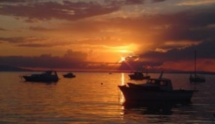Západ slunce nad mořem s loďkami 