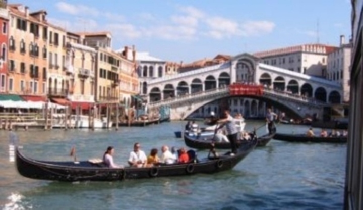 Lidé v loďce plující přes Canal Grande v Benátkách 