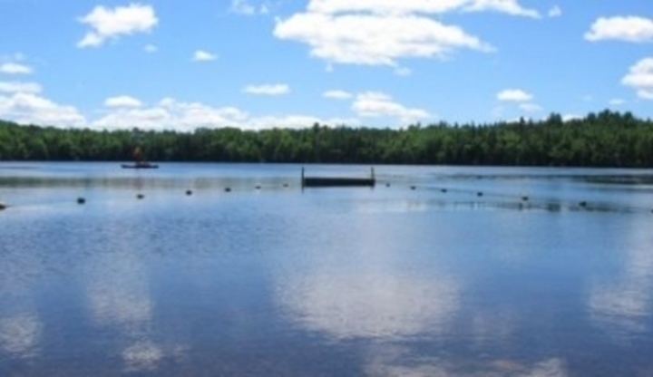 Fotografie jezera s odrazem bílých mráčků ve vodě 
