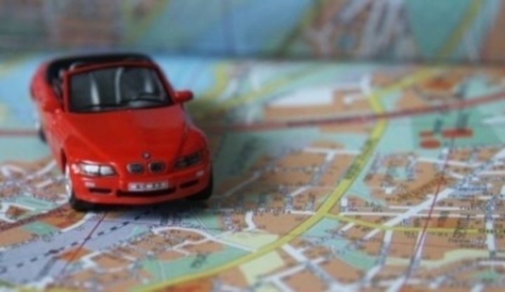 Červený model auta stojící na mapě