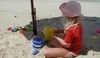 Dítě sedící v písku na pláži 