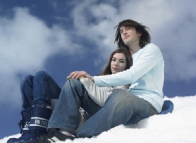 Žena sedící s mužem na sněhu 