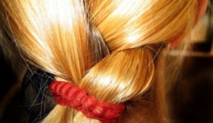 Zapletené vlasy s červenou gumičkou 