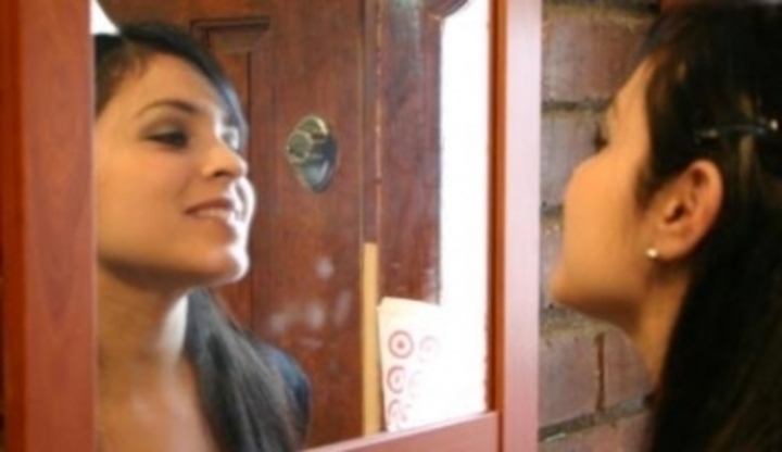 Dívka dívající se na sebe do zrcadla 