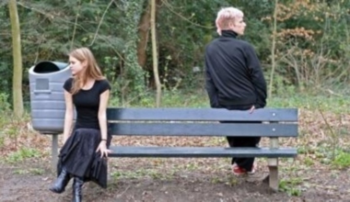 Muž se ženou u lavičky otočení zády k sobě  