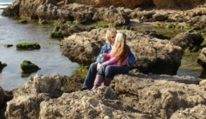 Líbající se dvojice na kamenech u moře