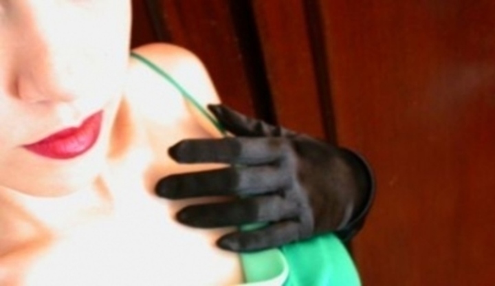 Ruka v černé rukavici položená na těle ženy 