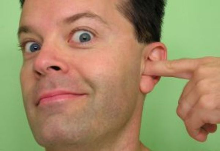 Muž šťourající se v uchu