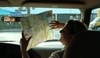 Žena v autě držící mapu  