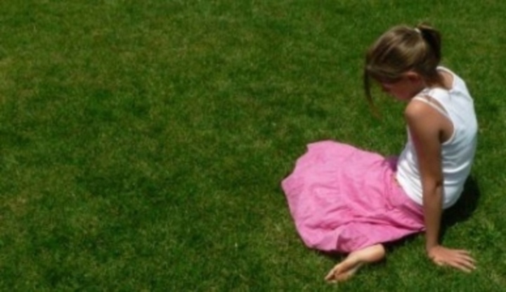 Dívka sedící na trávě 