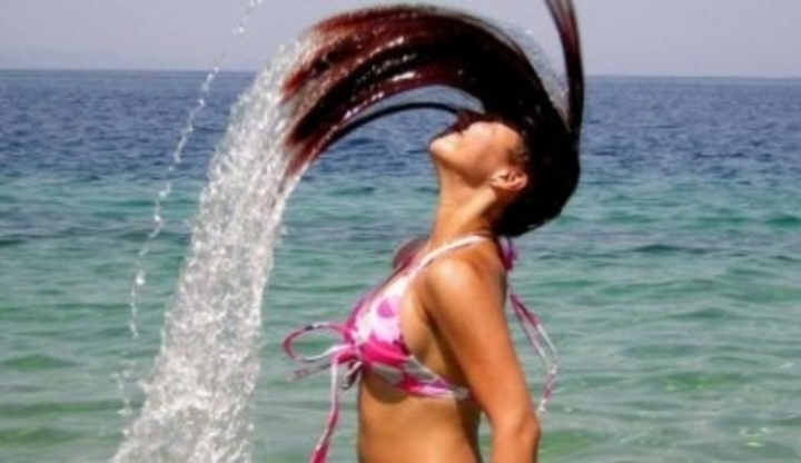 Žena zaklánějící hlavu s mokrými vlasy 