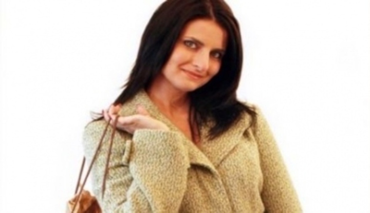 žena v kabátě držící na rameně kabelku