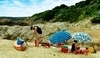 Lidé na pláži se slunečníky 
