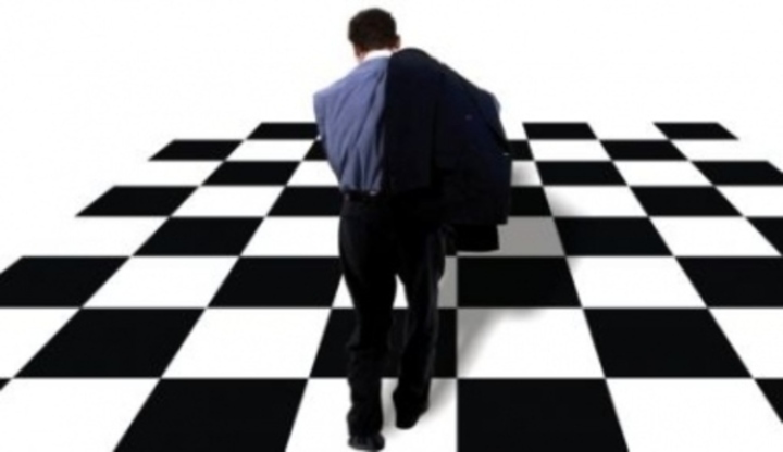 Muž jdoucí po černobílé šachovnicové podlaze 