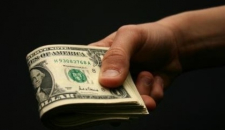 Ruka držící dolarové bankovky  