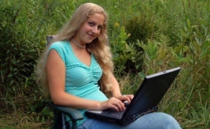 Sedící žena s notebookem na klíně