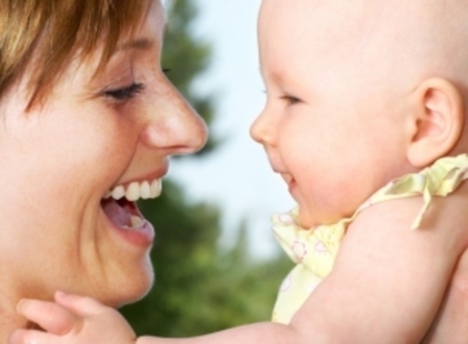 Smějící se žena držící miminko 